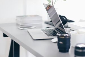 Opgeruimd bureau met een openstaande laptop en smartphone